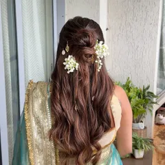 For this baby shower, I created a half-up style with a messy floral bun and soft waves, accented with delicate golden leaf charms for a touch of whimsy.