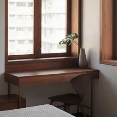 This built-in study desk is designed to maximize a compact space without sacrificing style. Crafted from warm wood and supported by slender brass legs, it feels both light and fully integrated with the window nook.