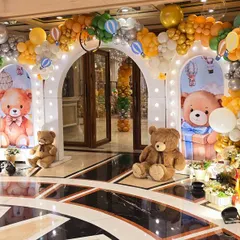 An enchanting hot air balloon and teddy bear themed entrance, with multiple arches and props creating a magical pathway.