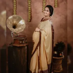 A standing pose that beautifully showcases the baby bump and the elegant drape of the saree. This is another lovely shot from our nostalgic, vintage-themed maternity session.