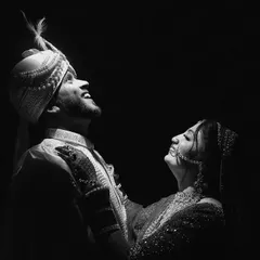 A dramatic black and white portrait of a couple looking up into the light. This artistic shot focuses on hope and shared joy.