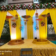 For a Haldi ceremony, it's all about bright, happy colors. This setup features a traditional yellow drape backdrop, decorative Rajasthani umbrellas, and low seating (baithak) for the rituals, making it perfect for photos and creating a festive vibe.