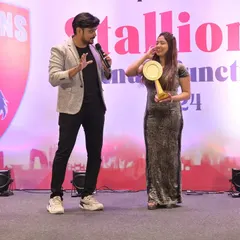 Sharing a light-hearted moment with an award winner on stage. I make sure the awards ceremony feels personal and celebratory, not just a formal list of names.