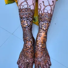 Intricate floral patterns on the bride's feet, designed to match the henna on her hands. The detail extends to every toe.