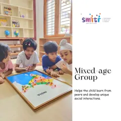 In our mixed-age classrooms, older children often become mentors to their younger peers. Here, a group of children collaborates on a puzzle map of India, learning geography and social skills together.
