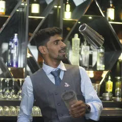 A flair bartender in his element, effortlessly tossing a shaker. This is the kind of entertainment and skill that elevates a standard bar service into a memorable performance.
