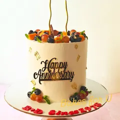 For special milestones, I create elegant cakes like this tall anniversary cake. It features a smooth buttercream finish and a generous topping of fresh, seasonal fruits like grapes and oranges.