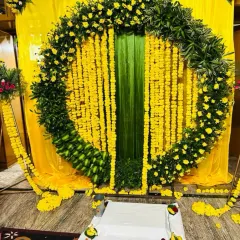 A closer view of the Haldi arch, showing the texture of the marigold strings and the base made of small banana plantains.
