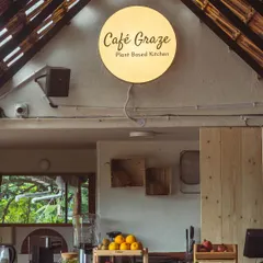 The warm glow of our Cafe Graze sign at the counter. Behind this counter, we blend smoothies, press fresh juices, and prepare meals using only the freshest, organic, and seasonal ingredients.