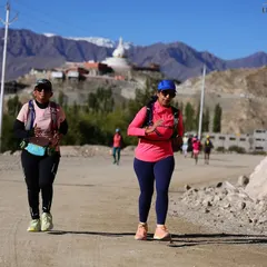 Two runners pacing each other on a dusty trail during the Ladakh Marathon. The sense of teamwork and mutual support is crucial in these endurance events.