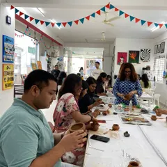 A bustling pottery workshop in session. It's a fantastic group activity where everyone can get their hands dirty and create something unique.