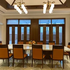 The same dining room viewed towards the full-length windows, which connect the space to the outdoors and can be opened to the veranda.