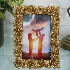 A romantic and ornate photo frame, intricately detailed with a border of golden roses. This frame is perfect for displaying wedding photos or any cherished family portrait.