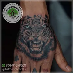 A realistic tiger tattoo, placed right on the hand. This kind of detailed black and grey work in a high-motion area requires precision and expertise to ensure it heals and lasts beautifully.