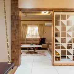 We used a geometric wooden screen to create a subtle partition between spaces, allowing light and views to pass through. The traditional indoor swing, or 'jhoola', adds a playful and classic South Indian touch to the modern living area.