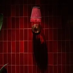 A close-up of the red wall tiles at Hikki. The way the light hits the glossy surface creates beautiful reflections and shadows, adding depth and texture to the wall. This simple detail demonstrates how the right tile and lighting can create a powerful mood.