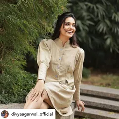 Actress Divya Agarwal smiling in our structured jute linen tunic dress. This versatile piece, with its high neck and puff sleeves, can be styled for a casual day out or a more formal event.