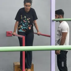 Even with assistance, form is everything. Our coach watches closely as a beginner works on her dip, ensuring her shoulders are safe and the movement is effective.