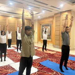 We guide employees at the Radisson Hotel through a standing asana. Our corporate yoga programs are designed to be practical and can be done in office wear, focusing on improving posture and energy levels during the workday.