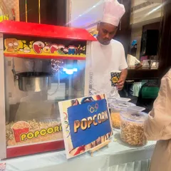 Our staff, dressed in a professional chef's uniform, serves fresh popcorn to guests at a birthday party.