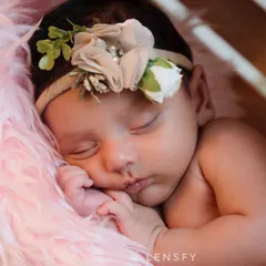 A close-up of a sleeping newborn, showing their perfect, delicate features. These are the tiny details you'll want to remember as they grow so quickly.