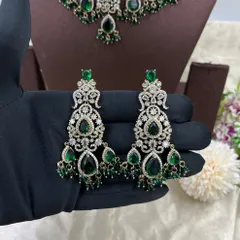 A heavy bridal choker set in a stunning emerald green. This design features multiple layers of stones and bead droppings, complete with matching oversized earrings, making it a comprehensive offering for your bridal customers.