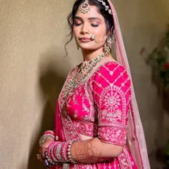A lovely side profile of a bride in her vibrant pink wedding lehenga. The intricate kundan jewellery she chose from my collection adds the perfect touch of traditional elegance.