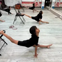 Our young dancers using chairs as a tool to safely deepen their splits. We use various techniques to help students improve their flexibility and prevent injury.