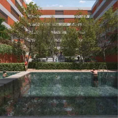 This view showcases the relationship between the architecture and the landscape. The swimming pool is surrounded by dense greenery and seating areas, creating a resort-like feel within the residential community.