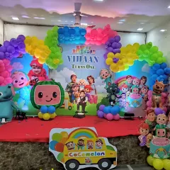 A vibrant and colorful Cocomelon theme for a first birthday party. This setup is packed with characters from the show, a rainbow balloon arch, and a custom backdrop to create a fun and cheerful atmosphere for the little ones.