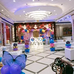 A wide view of the grand butterfly-themed setup for Kavya's first birthday. I can transform any banquet hall into a colorful wonderland, from the main stage to the entrance and seating area.