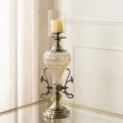 This candle stand features a beautiful mix of textured glass and antiqued metal with ornate scrollwork. It has a stately presence, perfect for adding a touch of vintage glamour to a side table or mantelpiece.