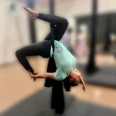 Learning to fly in an aerial hammock. This scorpion backbend variation, supported by the hammock, allows for a deeper stretch than what might be possible on the mat, improving flexibility while inverted.