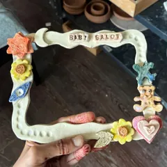 A student made this incredibly detailed and personal photo frame, complete with a name, stars, flowers, and even a little teddy bear. It's a cherished keepsake.
