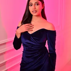 A soft glam look for a studio photoshoot. The deep blue velvet dress is complemented by a subtle smoky eye and a nude lip, creating an elegant and modern vibe.