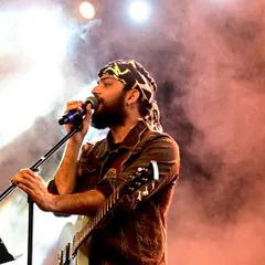 On stage with my guitar, surrounded by stage smoke and lights. This captures the rock and roll side of our performances.