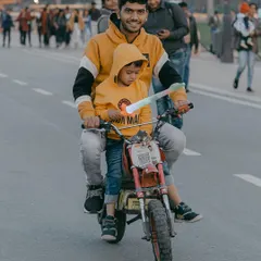 A heartwarming candid of a father and son enjoying a toy bike ride at India Gate. I love capturing these simple, joyful family moments that happen every day.
