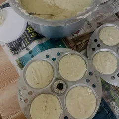 Preparing soft and fluffy idlis from our homemade batter. You can see the batter being poured into the idli stand, ready for steaming.