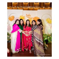 The mom-to-be surrounded by friends and family in front of the "Baby in Bloom" backdrop. Our decor creates the perfect setting for these cherished photo moments.