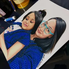 A custom mother-daughter portrait, seen here on my work desk. This 9x12 inch sketch was made with a full set of 72 Prismacolor pencils on smooth Strathmore paper to ensure the colors are bright and the art lasts a lifetime.