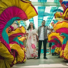 A moment of calm amidst the carnival chaos. This shot captures the couple surrounded by the vibrant colors and energy of our carnival dancers, showcasing how we create beautiful photo opportunities within the celebration.