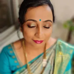 A close-up of Mallika's eye makeup. The soft gold shimmer on the lids and the defined eyeliner create a sophisticated look that is perfect for a daytime family function.