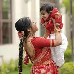 The purest love. A mother dressed in a beautiful red and gold Banarasi saree lifts her son, who wears a matching custom red kurta. Creating these coordinated legacy pieces is one of my greatest joys.