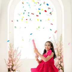 Pure birthday joy. This shot captures the excitement of an older child's celebration with a burst of colorful confetti against a bright, clean backdrop.