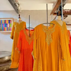 A display of flowy, festive silhouettes by Sheetal Batra in vibrant shades of orange and yellow, perfect for easy, breezy celebrations.