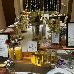 An elegant table setting is a must for any house party. This birthday celebration features a beautifully arranged buffet with gold-accented serveware, fresh flowers, and personalized signage.