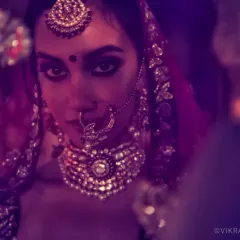 The Bridal Story. A moody, cinematic shot from a campaign for Shyamal & Bhumika, using colored light and shadow to create a dramatic and intimate bridal portrait.
