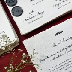 A closer look at the Adidas employee milestone notes. Details like the custom wax seal and delicate baby's breath sprigs elevate the stationery, making the recipient feel truly valued.