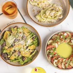 A beautiful overhead shot of our three signature salads, showcasing their vibrant colors and fresh ingredients.