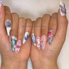 An underwater fantasy brought to life with 3D nail art. Each nail on this stiletto set tells a story, featuring hand-sculpted ocean creatures like seahorses and octopuses, plus florals, shells, and other textured details.